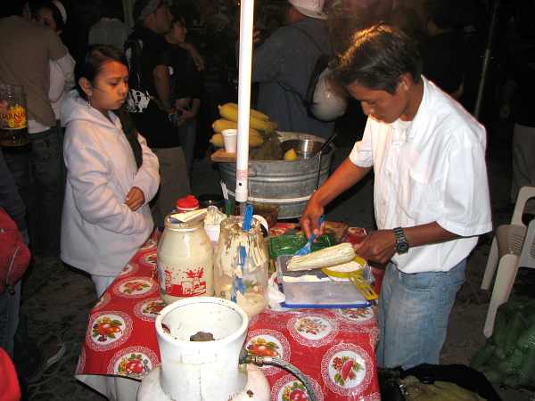 Cozumel street vender serving elote corn on the cob