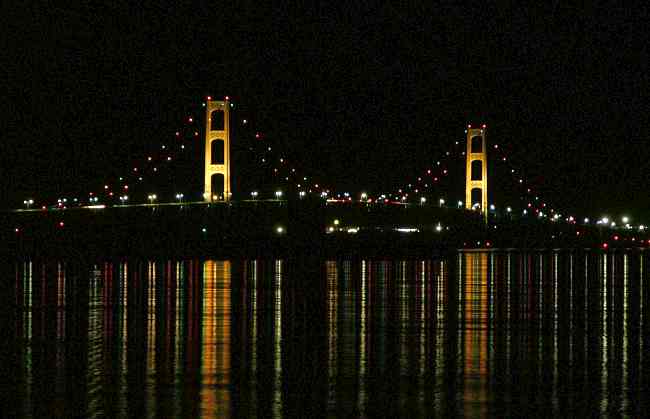 Mackinac Bridge at night with lights reflecting off the water