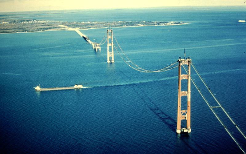 Aerial view of Mackinac Bridge construction and freighter