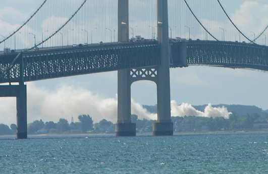 Mackinac Bridge with smoke rising above Mackinaw City in background
